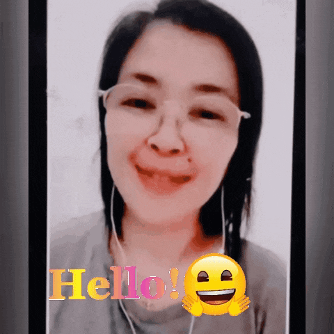 a woman wearing glasses and ear buds says hello on a phone screen