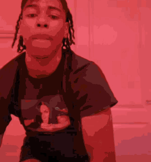 a man with dreadlocks is wearing a purple shirt with a picture of a woman on it