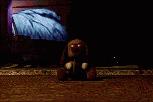 a teddy bear with red eyes is sitting on the floor in a dark room