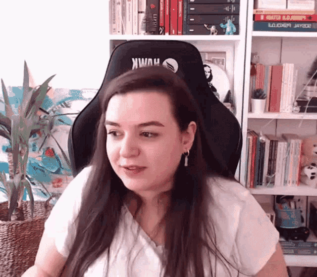 a woman is sitting in a chair with the word hawk on the back of it