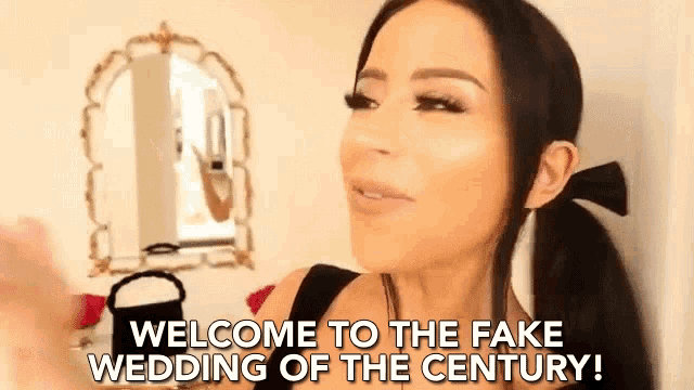 a woman is standing in front of a mirror with the words `` welcome to the fake wedding of the century '' written on her face .