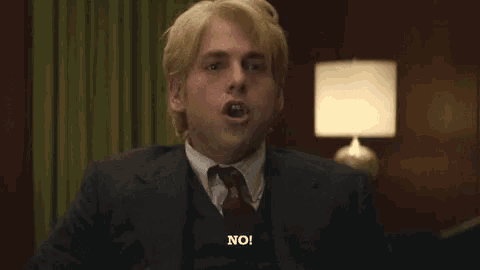 a man in a suit and tie says " forbidden speech about my dear friend ernie " in front of a lamp