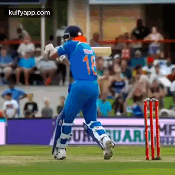 a cricket player wearing a blue jersey with the number 13 on it is running towards the wicket .