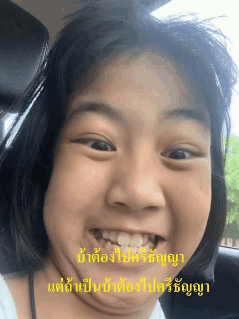a girl making a funny face in a car with chinese writing on the bottom right