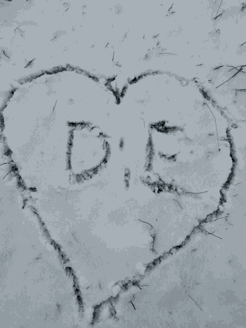 a heart is drawn in the snow with the letters d and e