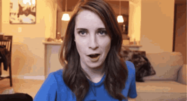 a woman wearing a blue shirt is making a funny face