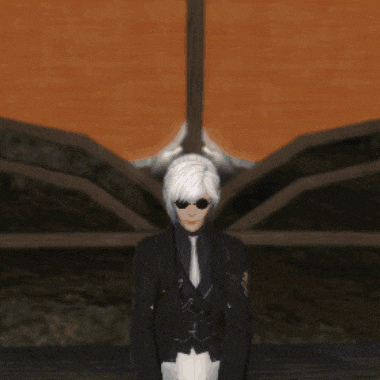 a woman with white hair and glasses is standing in front of a brick wall