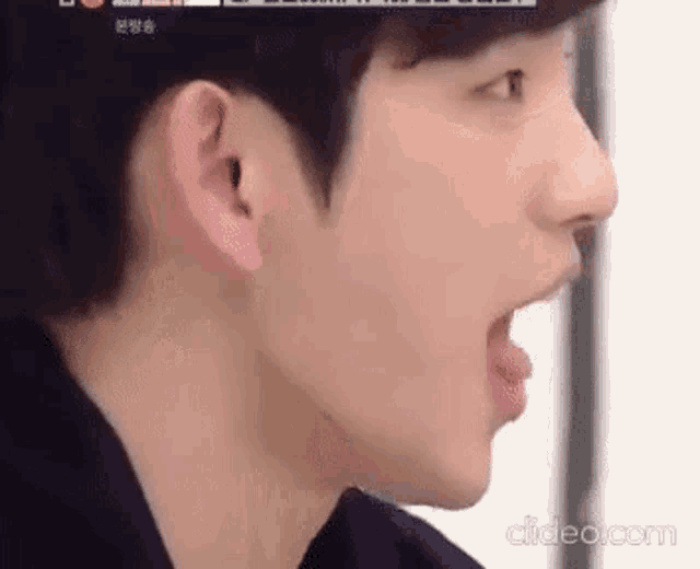 a close up of a young man 's face with his tongue out .
