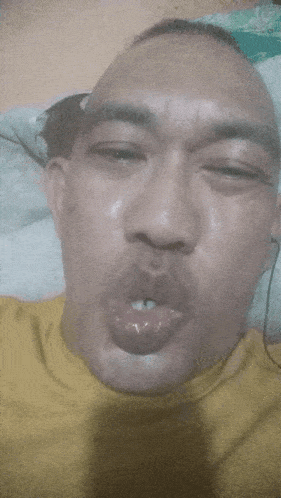 a man in a yellow shirt making a funny face