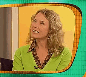 a woman in a green sweater is smiling and looking up
