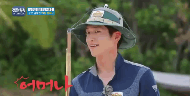 a man wearing a hat and holding a fishing rod is smiling .