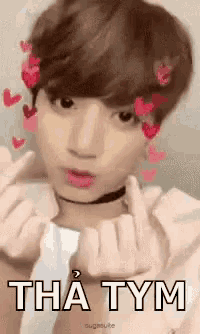 a young man is making a heart shape with his fingers .