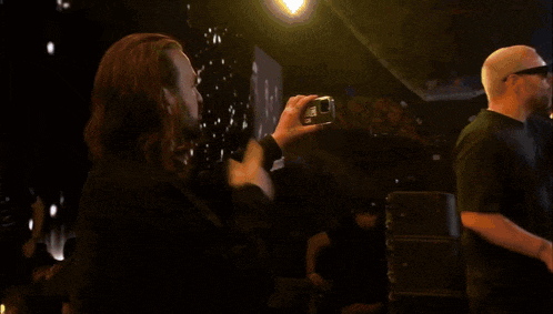a man with long hair and a beard is standing in front of a stage