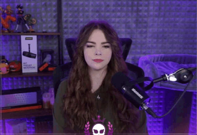 a woman sitting in front of a microphone that says shure