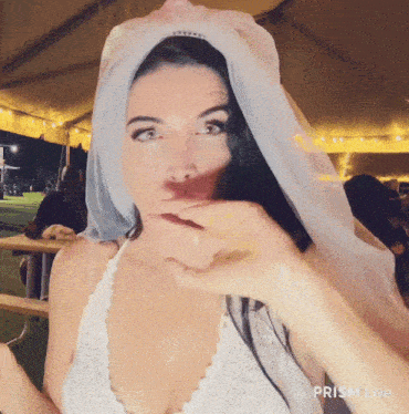 a woman with a veil on her head has prism live written on the bottom