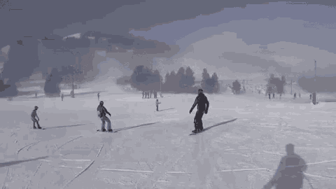 a group of people are skiing and snowboarding on a snowy mountain .