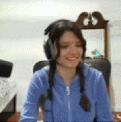a woman wearing headphones and a blue shirt is smiling .