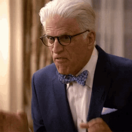a man in a suit and bow tie is talking to someone .