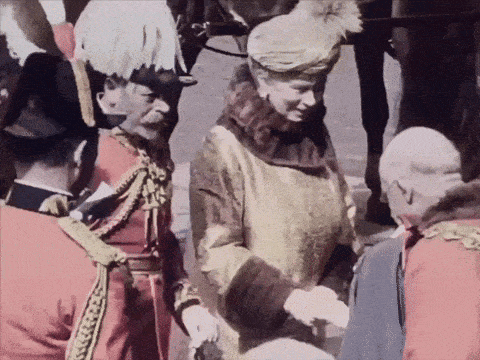 a woman in a fur coat shakes hands with a group of men