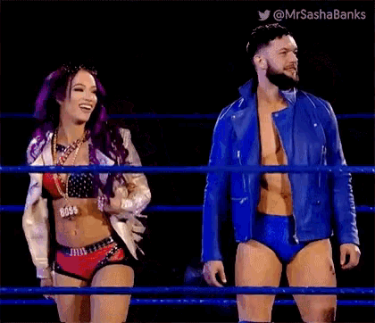 a man and a woman are standing in a wrestling ring and smiling .