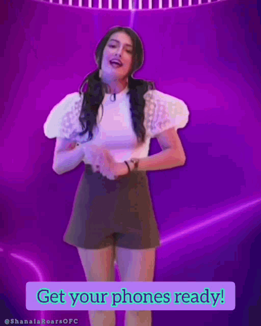 a woman is dancing in front of a purple background with the words " get your phones ready "