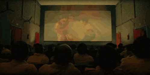 people are watching a movie in a dark theater