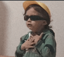 a little girl wearing sunglasses and a yellow hat has the letter d on her shirt