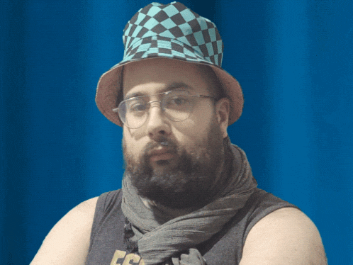 a man with a beard wearing glasses and a hat with a checkered pattern on it