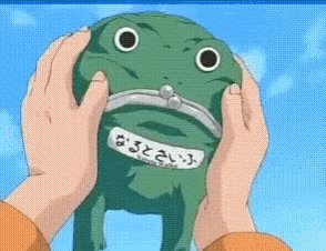 a person is holding a stuffed frog with a sticker that says ' naruto ' on it