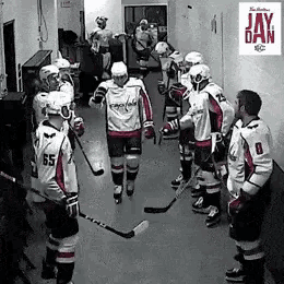 a group of hockey players are standing in a locker room with the word jay on the wall behind them