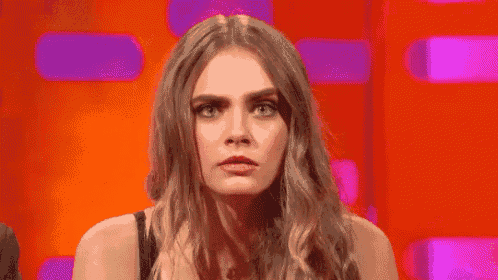 a woman is making a funny face with her eyes closed .
