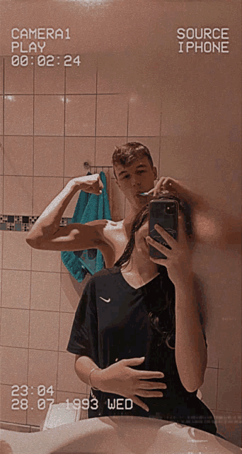a couple taking a picture of themselves in a bathroom with the date 28.07.1993 on the bottom right