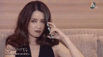 a woman sitting on a couch talking on a cell phone
