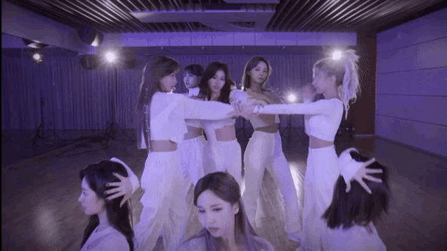 a group of women are standing in a dance studio