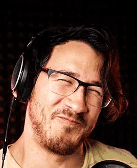 a man wearing glasses and headphones making a face