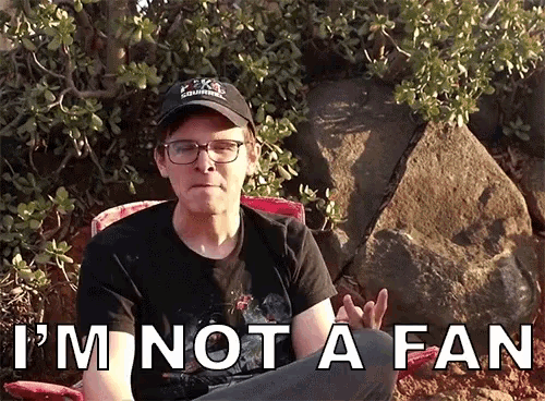 a man sitting in a chair with the words i 'm not a fan behind him