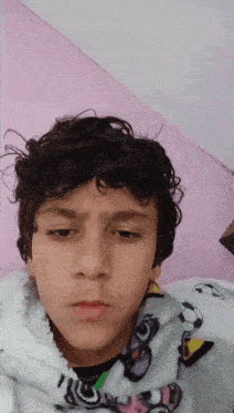 a young boy with curly hair wearing a blanket with a soccer ball on it