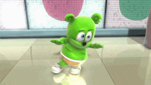 a green gummy bear dancing on a tiled floor