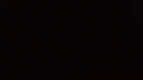a close up of a person 's face in a dark room with a red hat on .