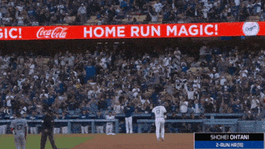 a baseball game is being played in front of a large coca cola sign