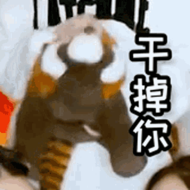 a stuffed animal with chinese writing on it is sitting on top of a bed .