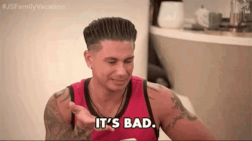 a man in a red tank top is pointing at something and saying `` it 's bad . ''