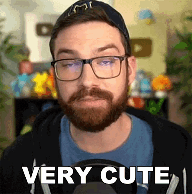 a man with glasses and a beard is making a very cute face