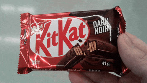 someone is holding a kitkat dark noir bar