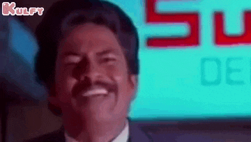 a man with a mustache and a suit is smiling in front of a sign .