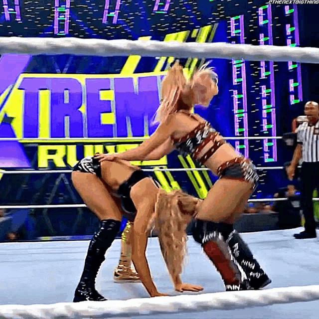 two women wrestling in front of a sign that says extreme