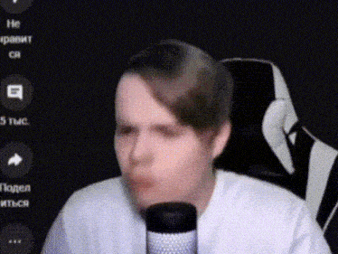 a man in a white shirt is sitting in front of a microphone