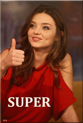 a woman in a red top gives a thumbs up in front of a super sign
