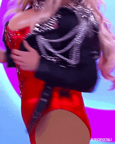 a woman in a red bodysuit is being held by a man in a black jacket with xtecrystali on the bottom