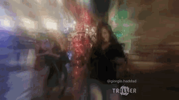 a blurry picture of a man and a woman in a dark room with the words triller on the bottom .
